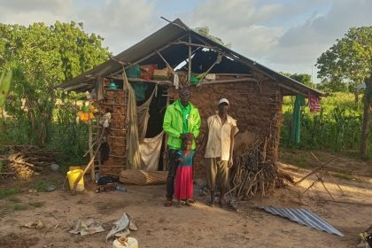 Kenianische Familie vor einer Lehmhütte